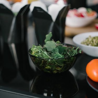 Close-up of fresh vegetables and takeout containers in a kitchen setting.